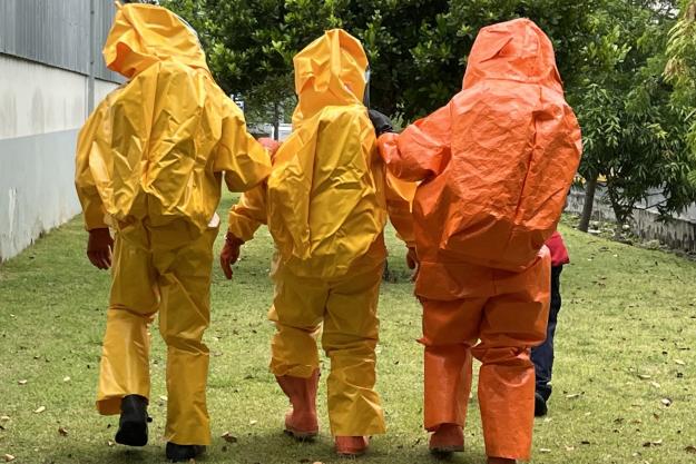 Participants wearing different levels of chemical protective equipment move through a training area during CHEMEX GRULAC in Santo Domingo, Dominican Republic. (Photo: OPCW)