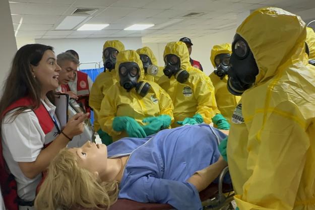 Medical personnel take part in a simulated chemical emergency scenario during CHEMEX GRULAC using an advanced training phantom representing a pregnant patient exposed to toxic chemicals (Photo: OPCW)