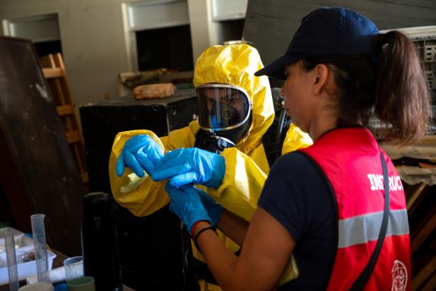 A first responder wearing protective equipment conducts sampling during a simulated chemical leak in a laboratory scenario as part of CHEMEX GRULAC in Santo Domingo, Dominican Republic. The exercise trained participants from across Latin America and the Caribbean in chemical detection, hazardous material response and coordinated emergency operations under realistic conditions. (Photo: Ministry of Defence of the Dominican Republic)