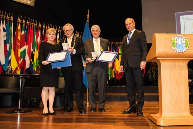 The inaugural OPCW-The Hague Award was awarded to Verifin, accepted by the Director Paula Vanninen, left, with Mr. Jozias van Aartsen, the mayor of The Hague; and Dr. Robert (Bob) Mathews, second from right with Director-General Ahmet Üzümcü at the 19th Conference of States Parties on 1 December 2014.